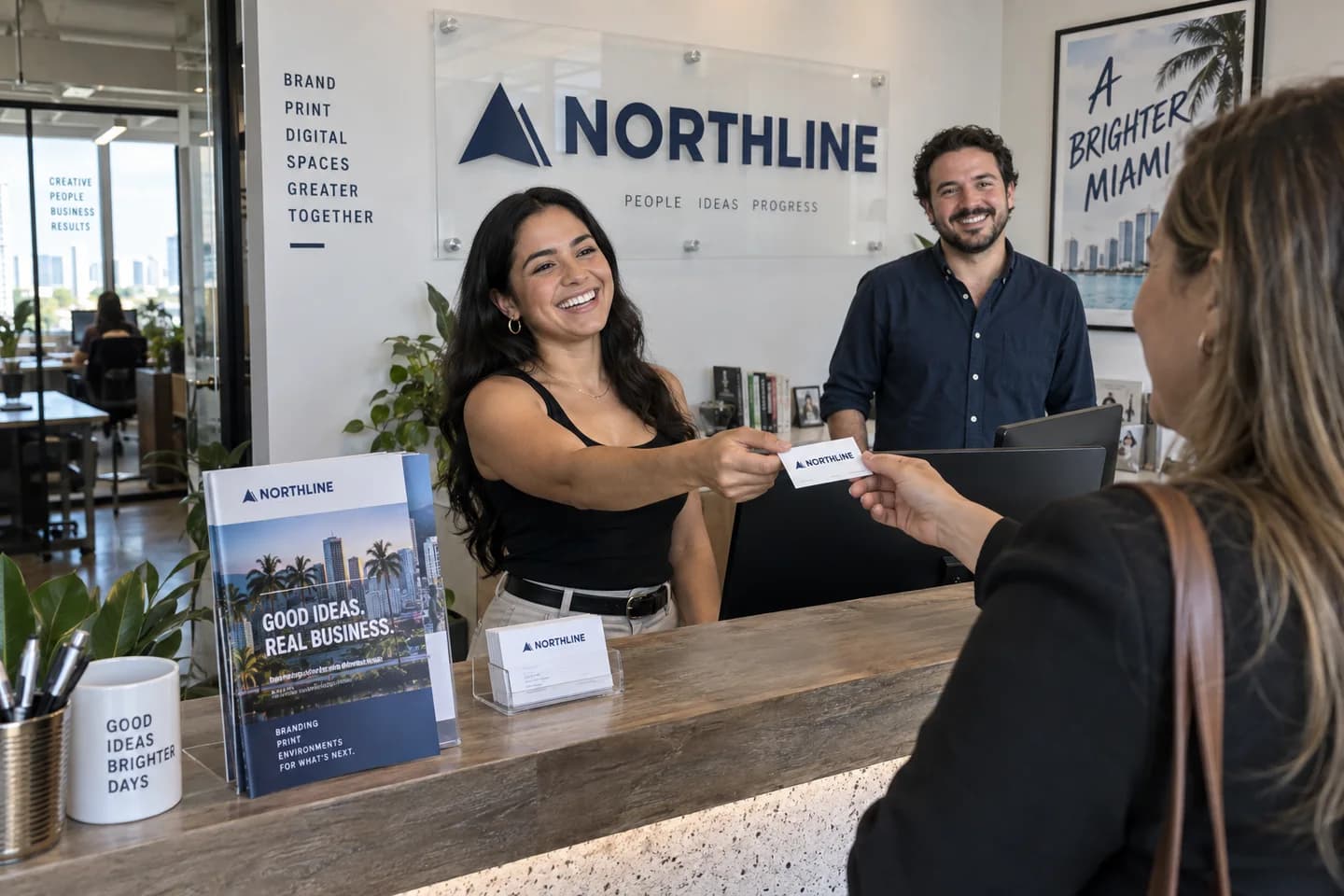 Northline team handing a branded business card to a visitor at reception